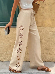 Back view of cream wide-leg pants with subtle floral embroidery