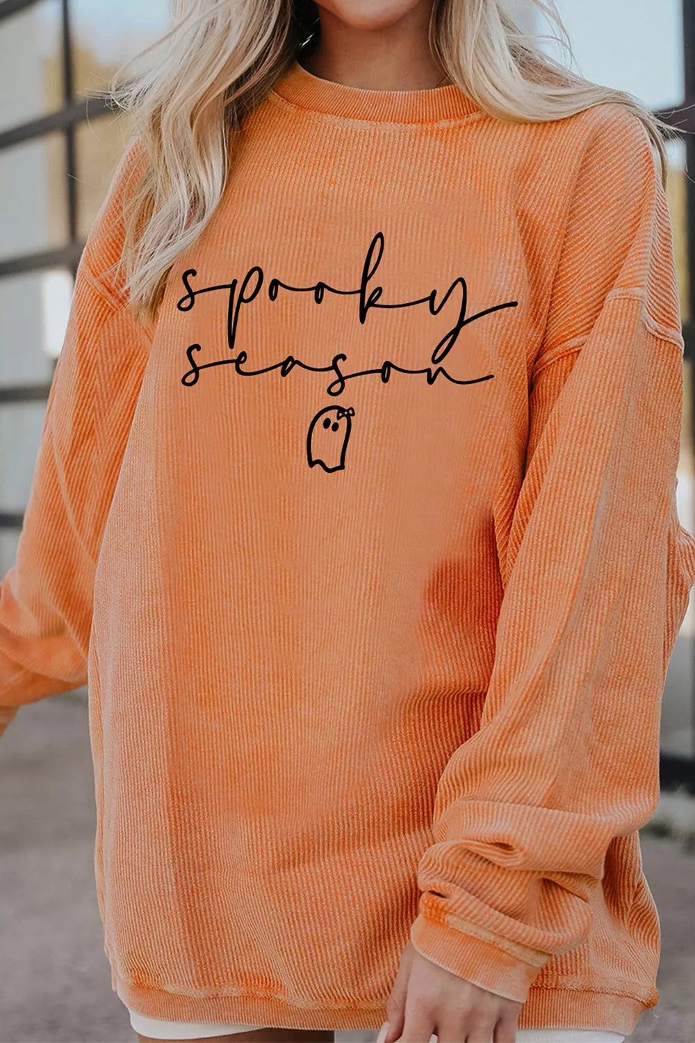 Front view showing crew neckline and long sleeves of orange sweatshirt