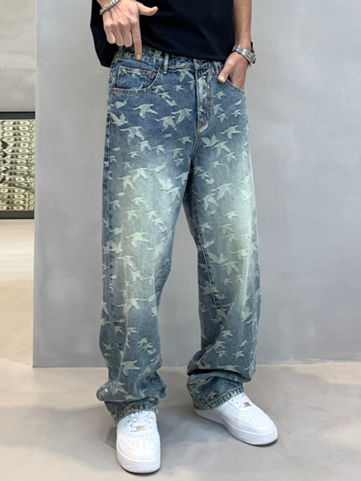 Front view of men's loose blue jeans with an all-over pale flying-bird pattern