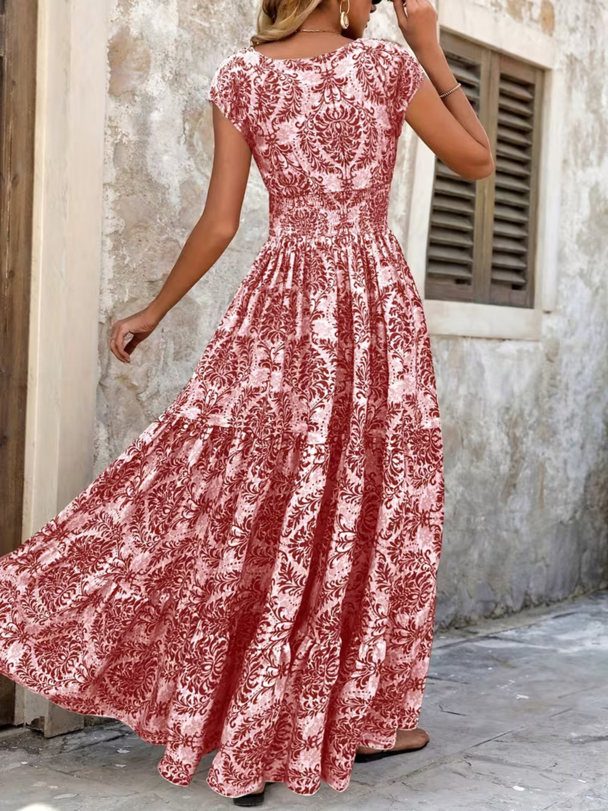 Green floral maxi dress shown from the back with the smocked bodice and flowing skirt.