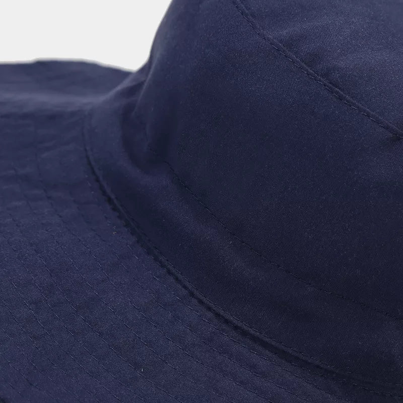 Close-up of the navy bucket hat's stitched crown and brim.