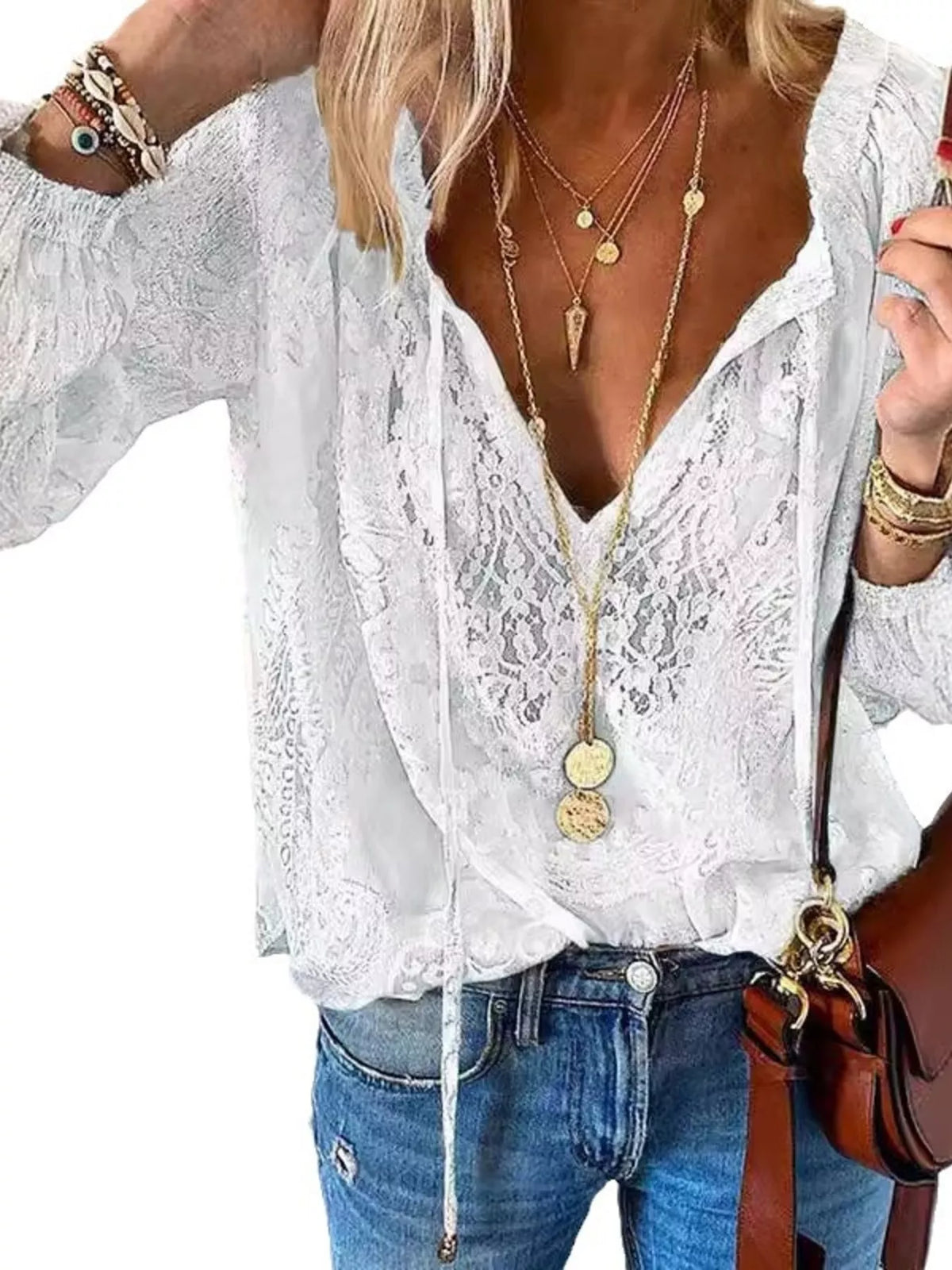 Close view of white blouse's sheer floral lace, V-neck and tied neckline