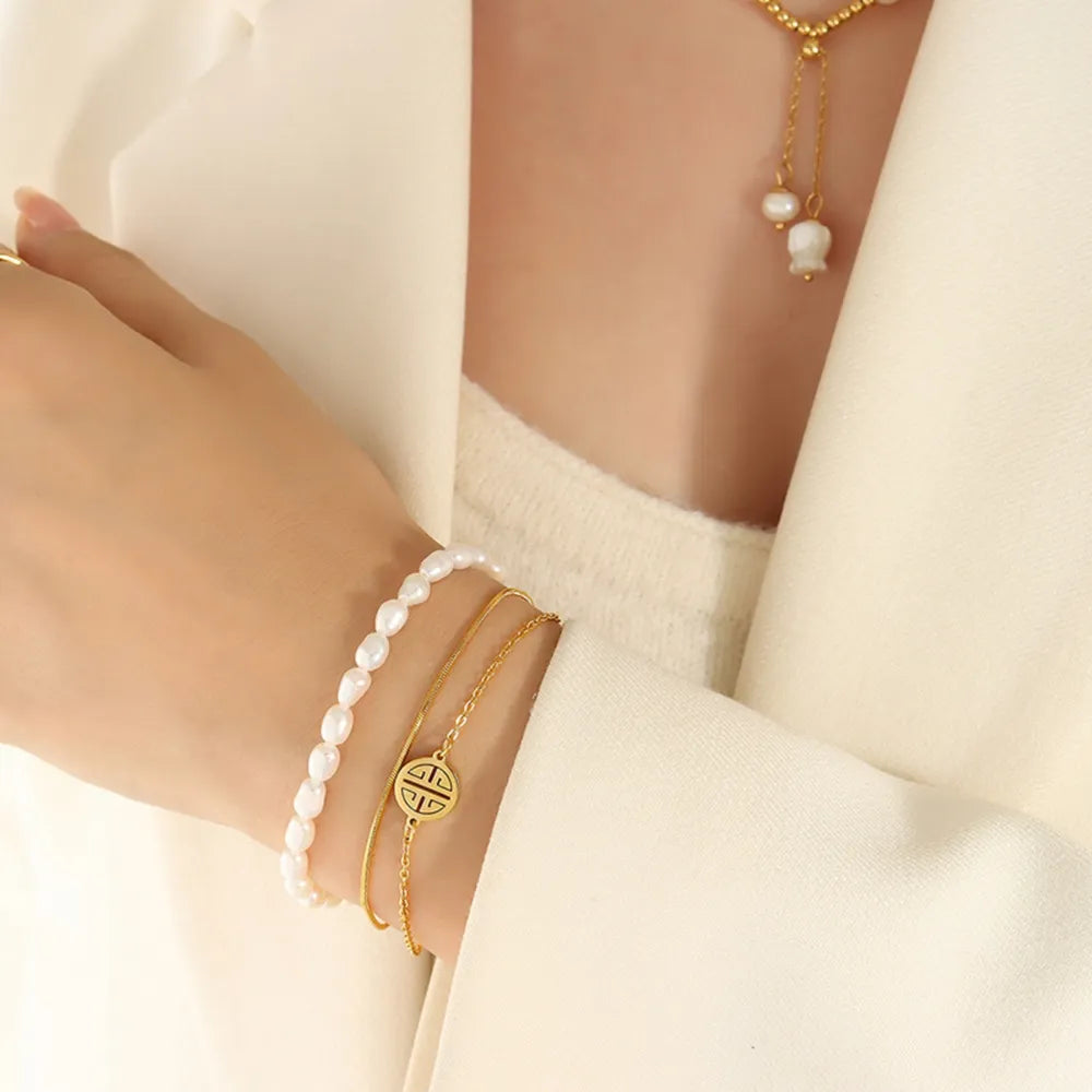 Gold and pearl bracelet worn on wrist