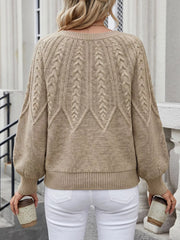 Back view of beige cable-knit sweater worn with white jeans