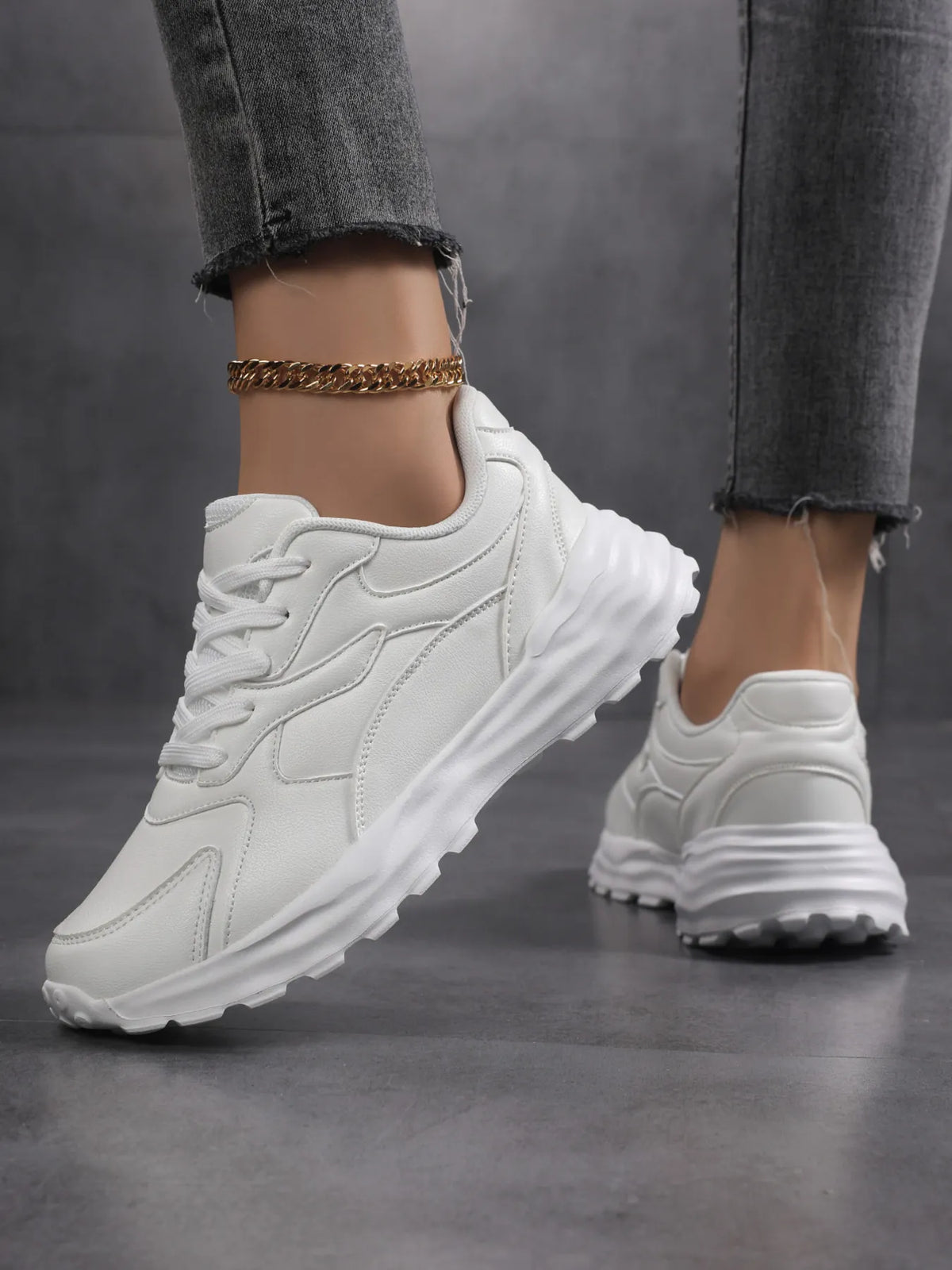 White chunky sneakers worn with jeans, side view