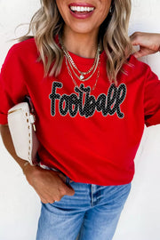 Front view of red football lettering tee styled with jeans
