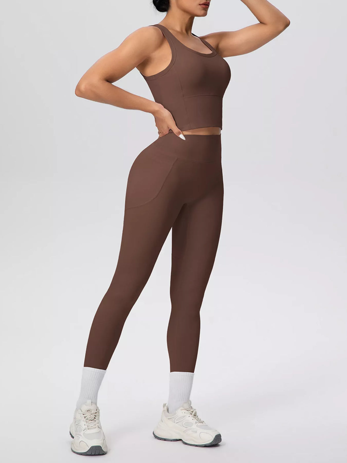 Brown leggings pocket holding a phone, shown with matching tank