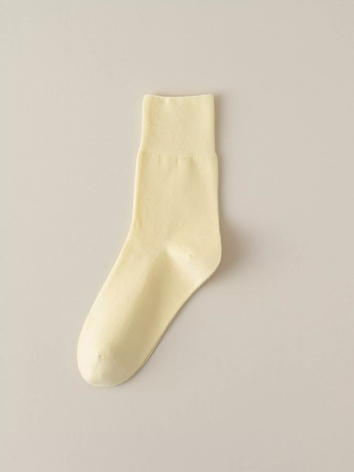 Pale yellow solid-color crew sock displayed flat