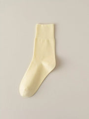 Pale yellow solid-color crew sock displayed flat