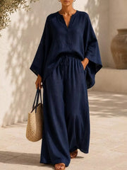 Woman modeling a navy notched top with matching wide-leg pants and a waist tie.