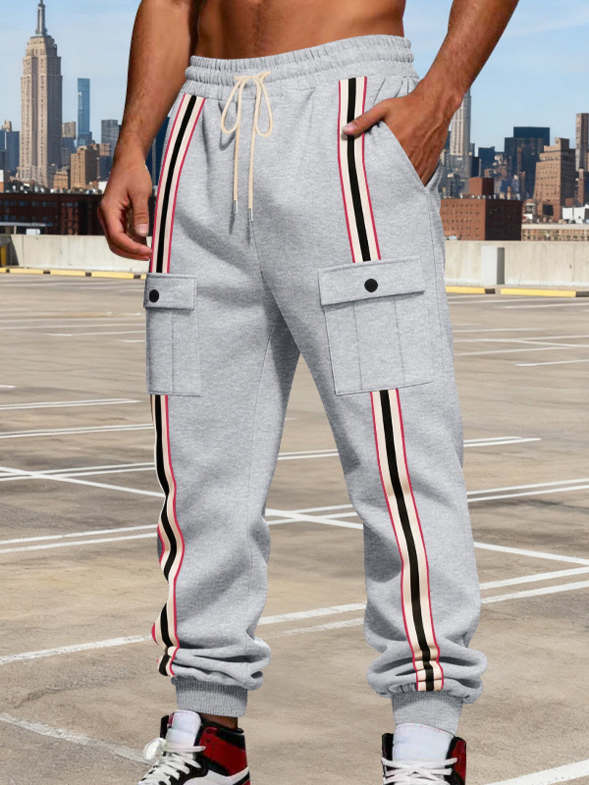 Model wearing gray striped cargo joggers in an urban setting