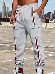 Model wearing gray striped cargo joggers in an urban setting