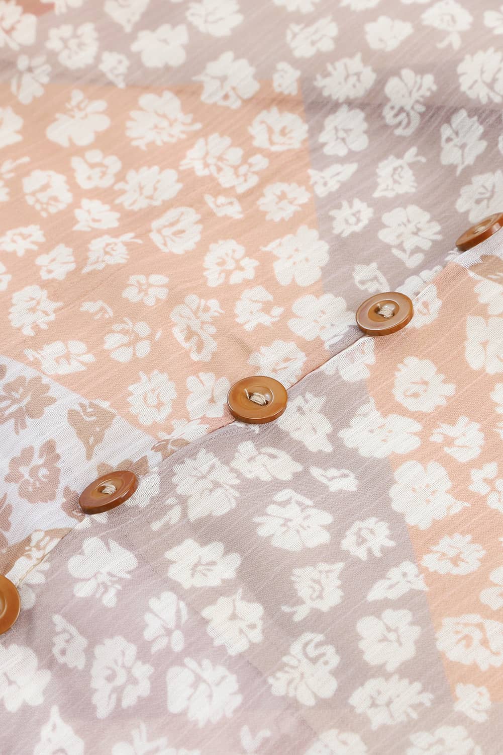 Close-up of floral skirt fabric and brown front buttons