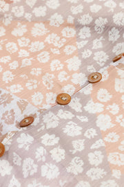Close-up of floral skirt fabric and brown front buttons