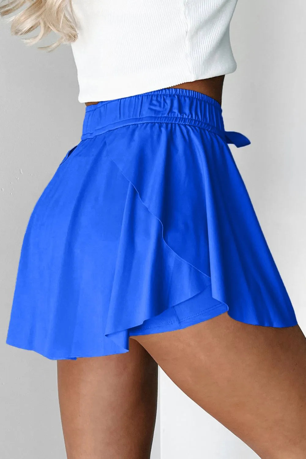 Side view of blue skort showing layered flounce over fitted shorts