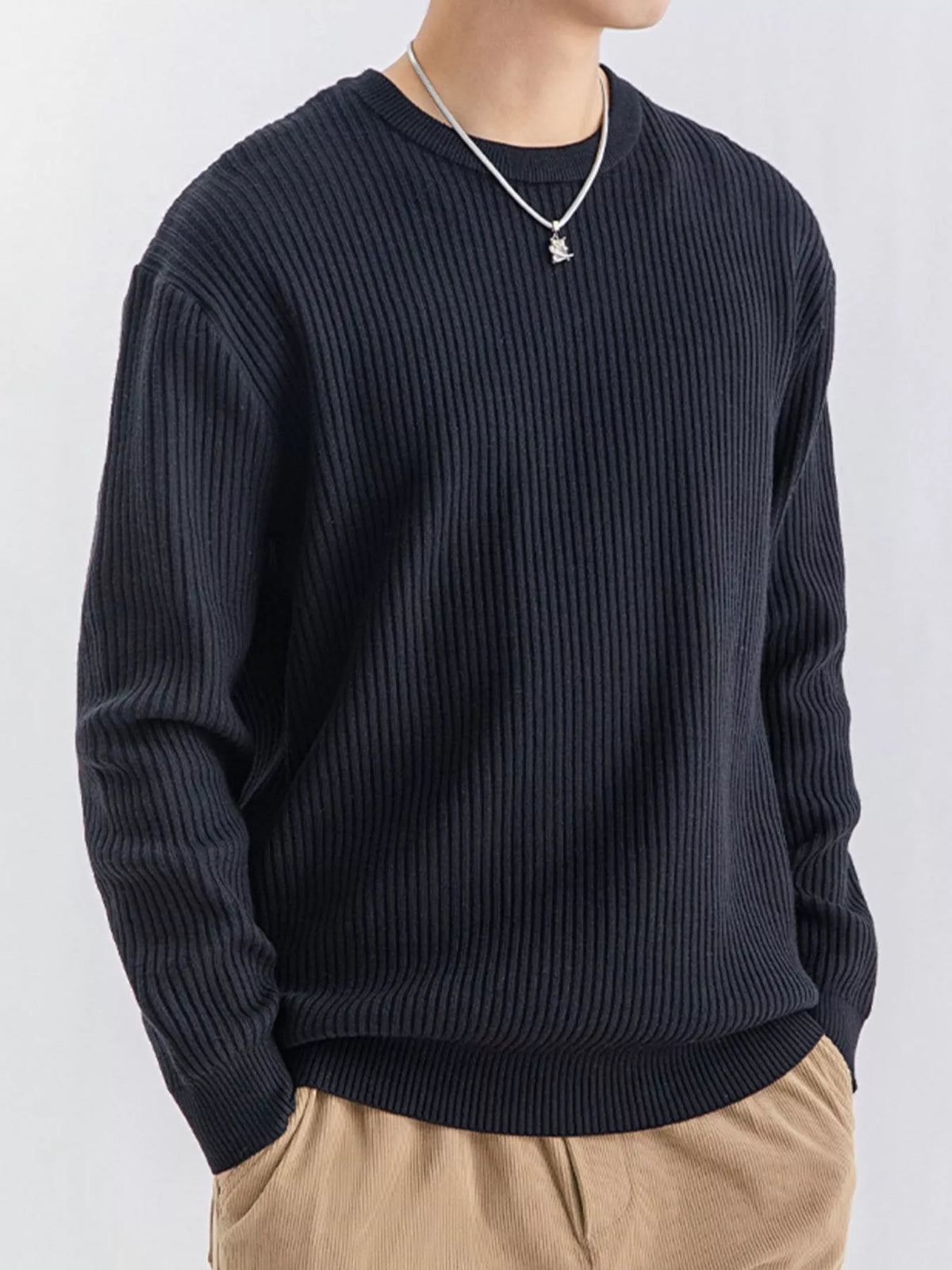 Angled view of dark navy ribbed sweater with a relaxed fit and ribbed cuffs
