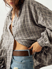 Close view of gray plaid shirt front, buttons and oversized sleeve