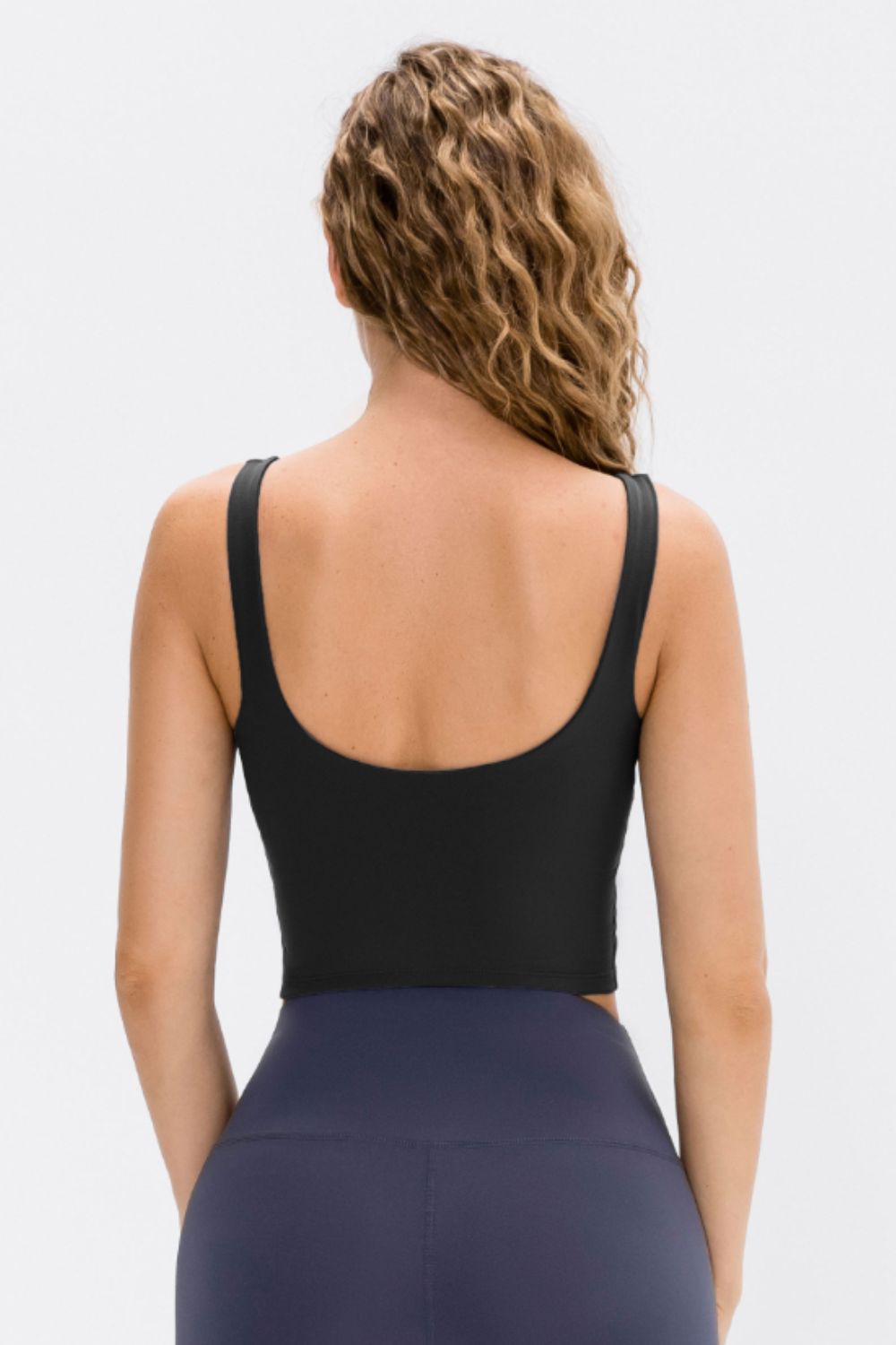Black cropped active tank top shown from the back with a low scoop back