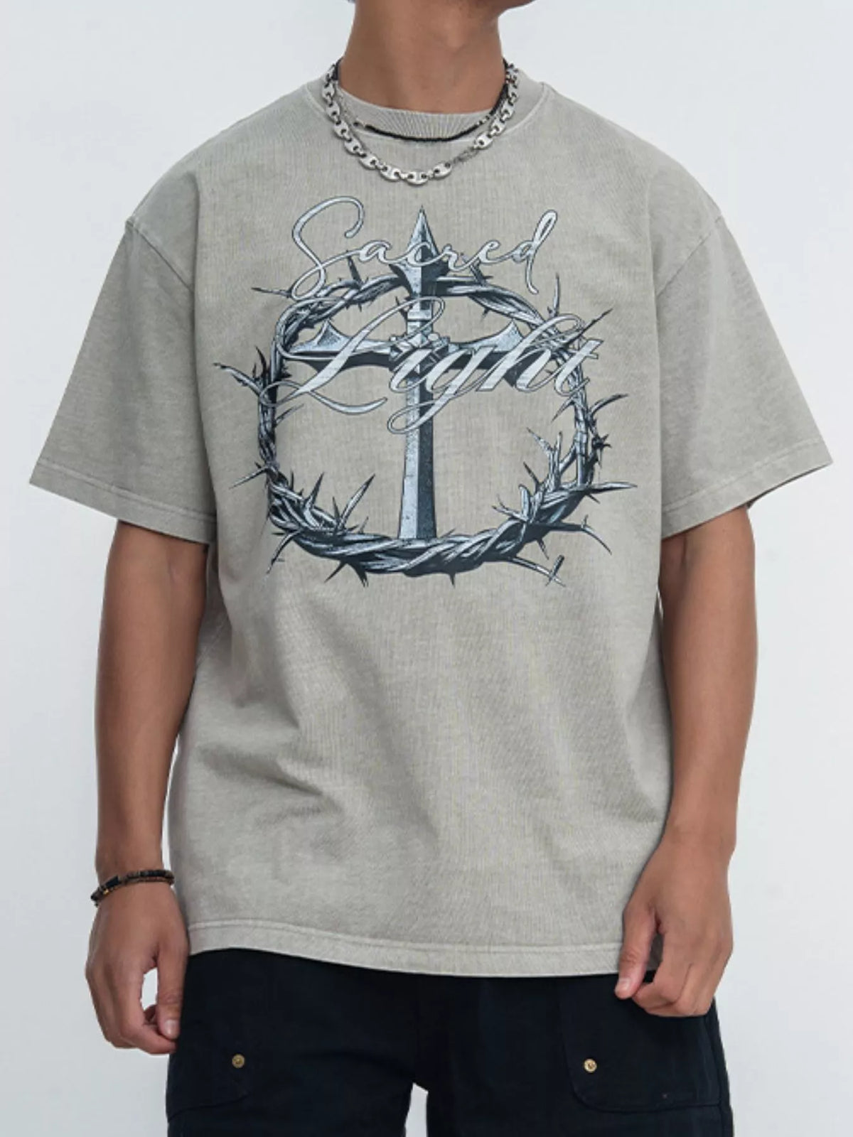 Model wearing light gray tee with ornate circular graphic
