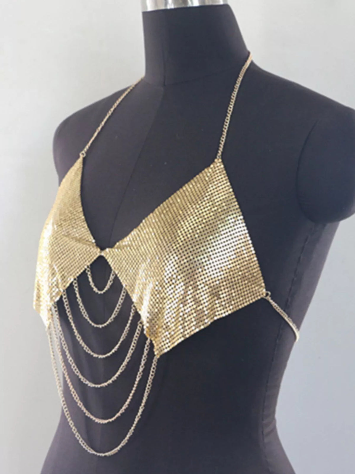 Close-up of reflective gold mesh and hanging chains