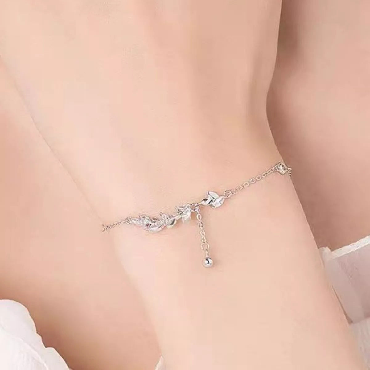 Side view of the silver leaf bracelet worn around a wrist
