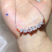 Moissanite pendant necklace held up to show its silver-tone chain