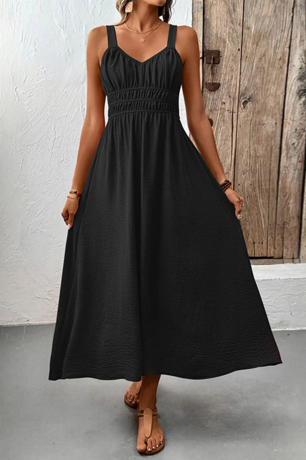 Full-length front view of black sleeveless cami dress with gathered bodice