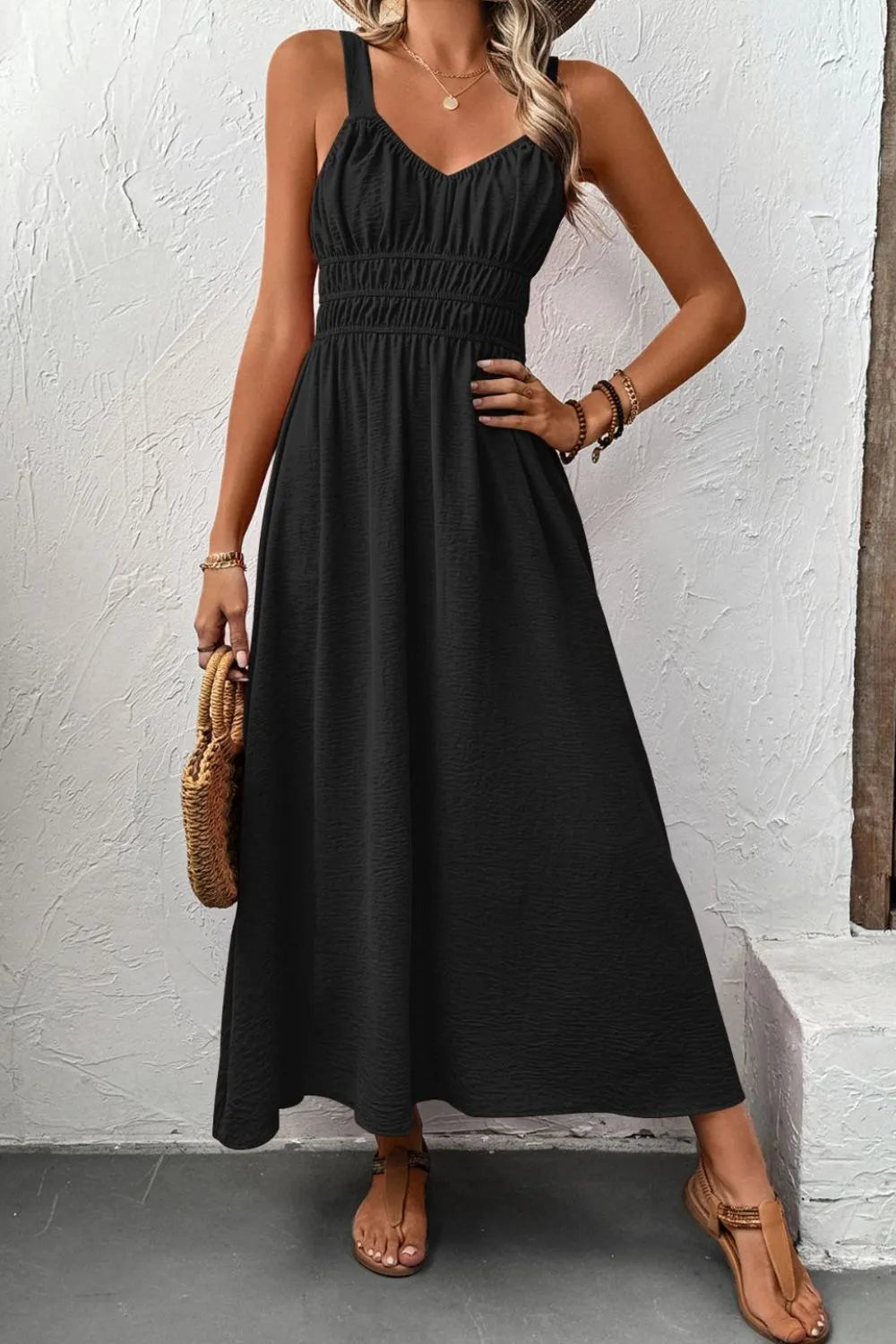 Front view of black wide-strap cami dress with gathered bodice and flowing skirt