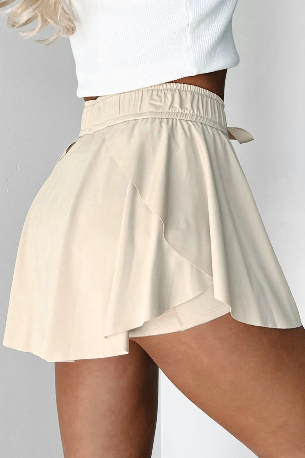 Side view of ivory skort showing the built-in shorts beneath the skirt overlay.
