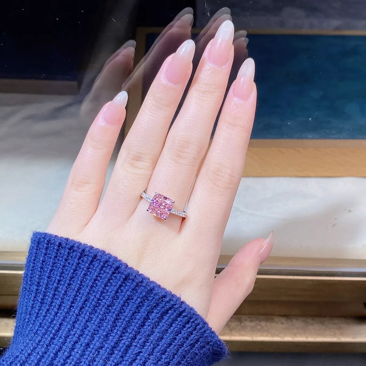 Square pink zircon ring worn on a finger