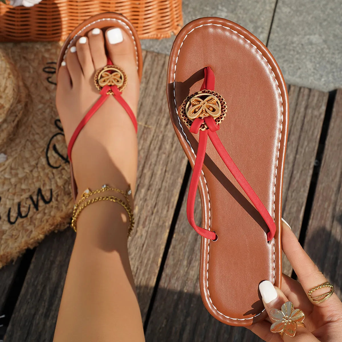 Red-strapped toe-post sandal held beside a matching worn sandal, showing brown footbed
