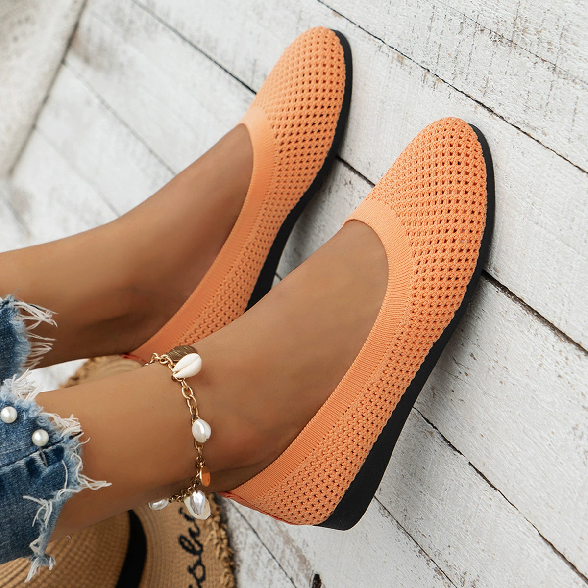 Orange mesh flats worn with cropped jeans, viewed from above