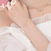 Silver leaf bracelet worn on the wrist beside a sheer sleeve