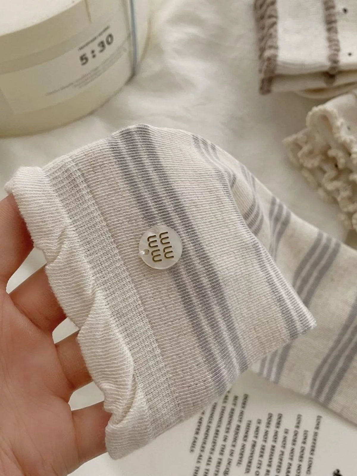 Pair of cream mid-calf socks with gray horizontal stripes and brown toes