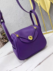 Angled front view of a purple crossbody bag