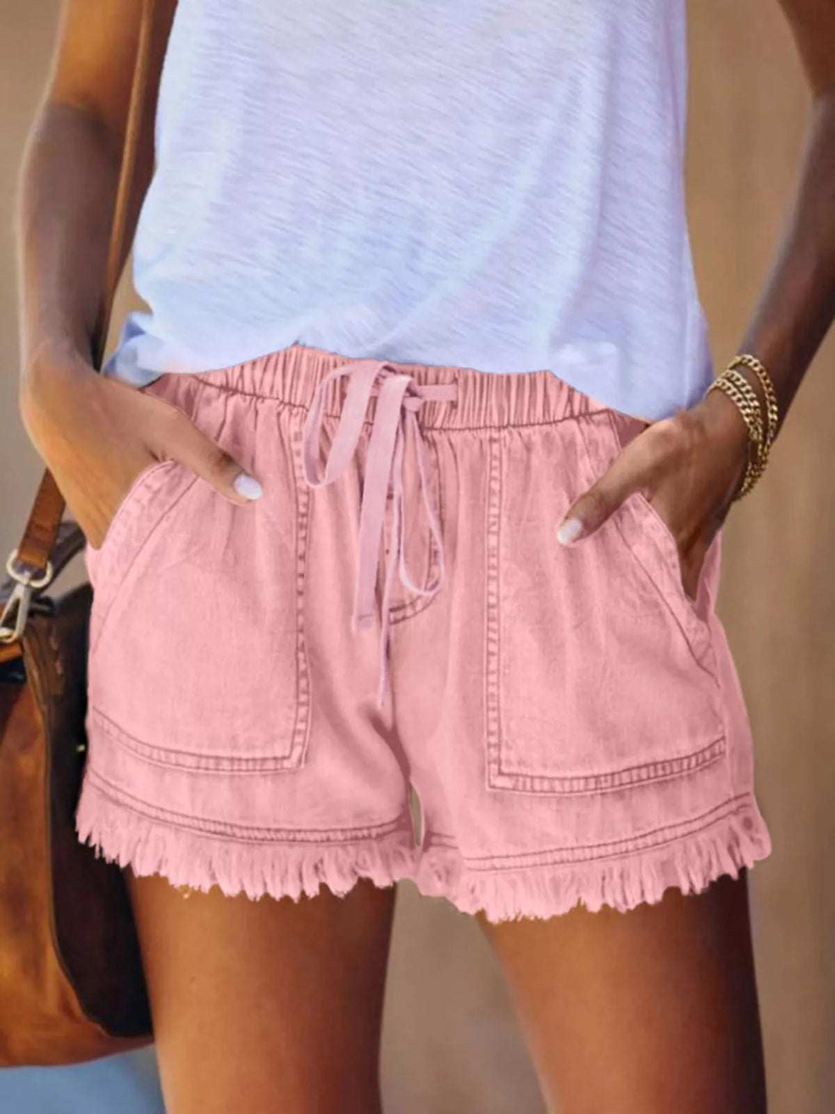 Pink drawstring denim shorts with front patch pockets and frayed hems