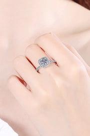 Close-up of square halo moissanite ring worn on a model’s finger.