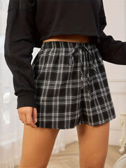 Side view of black-and-white plaid shorts with a black top