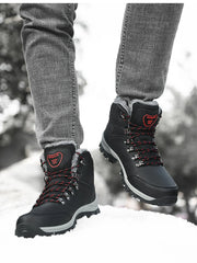 Black lace-up ankle boots with red-accented laces and grey midsoles, worn in snow