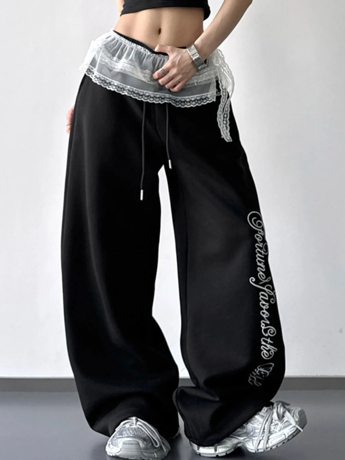 Black wide-leg pants with layered white lace waist detail