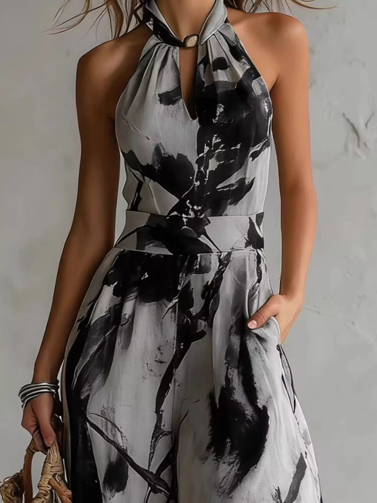 Close-up of the grey and black jumpsuit's halter neckline and defined waist.