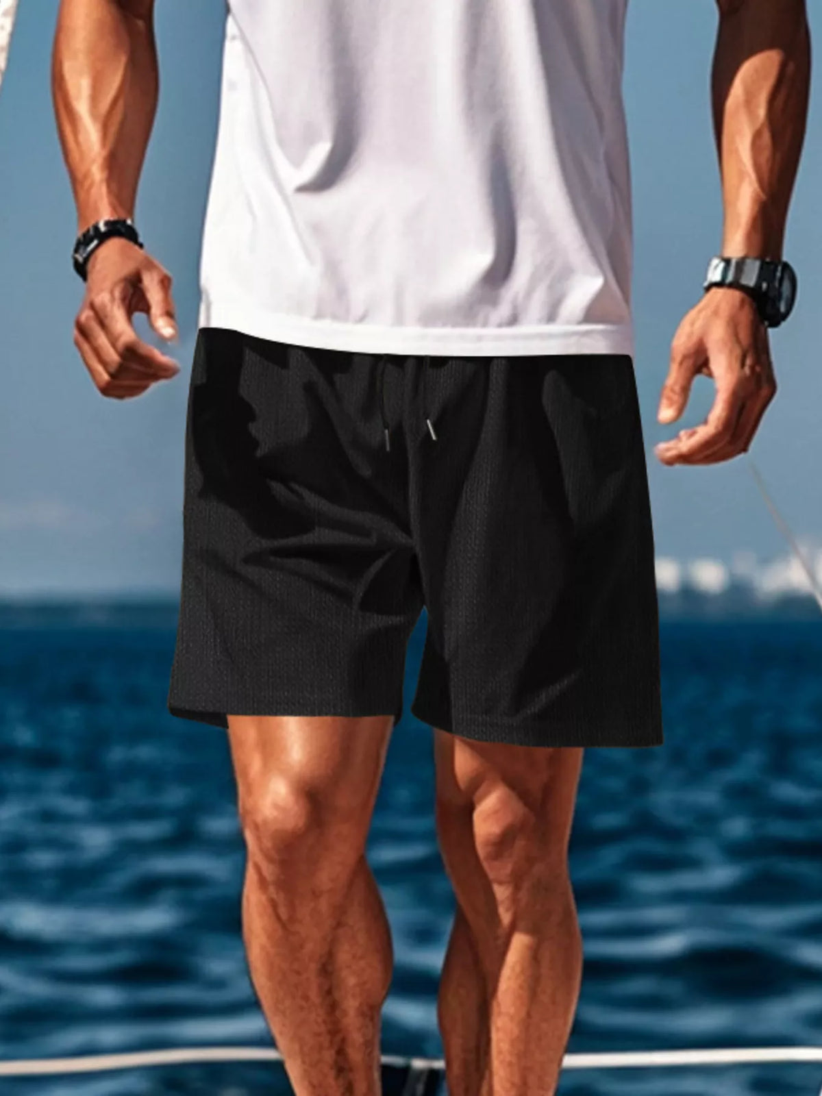 Side view of black drawstring shorts on a model