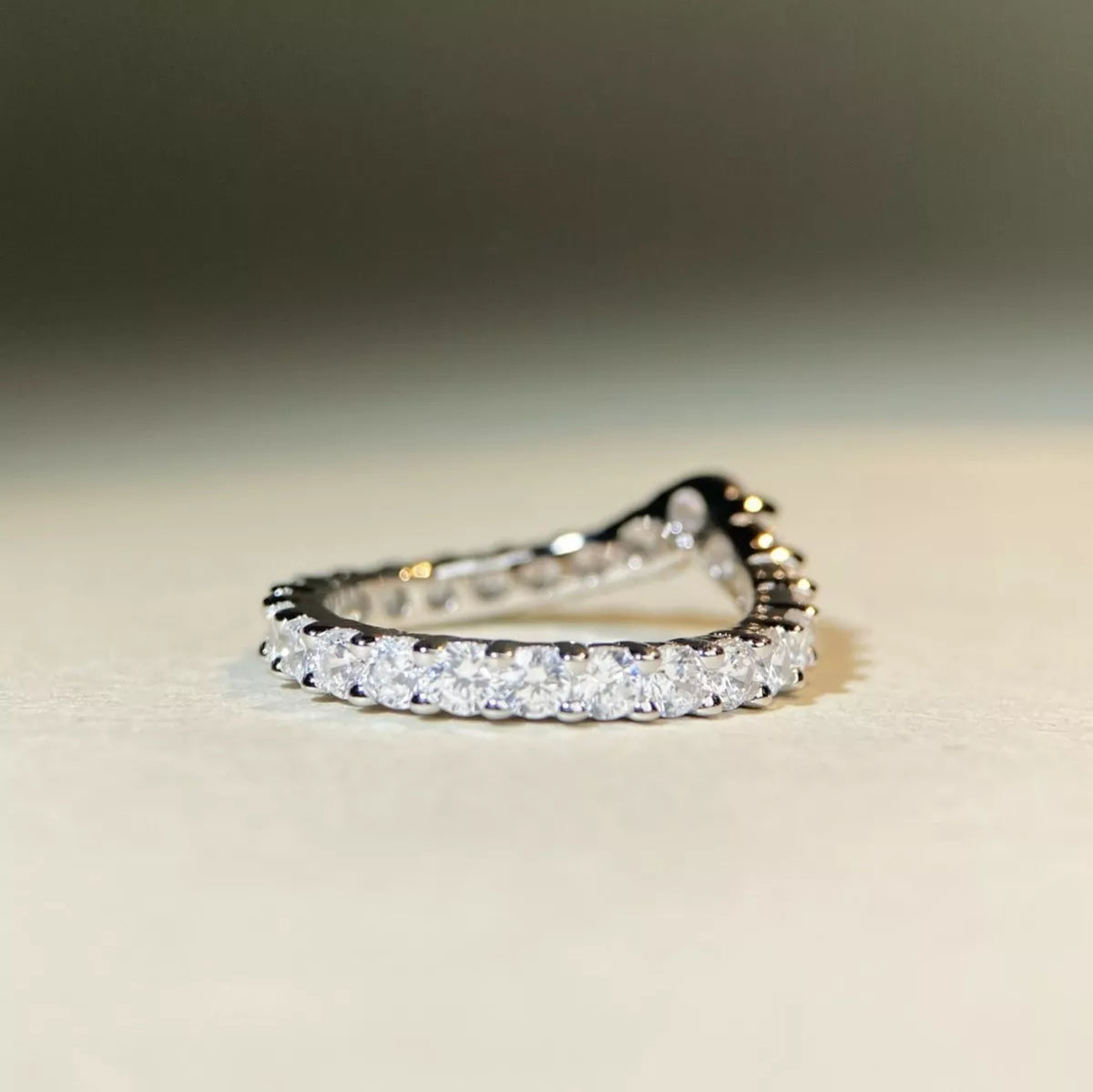 Side view of the row of clear stones set along the ring band.