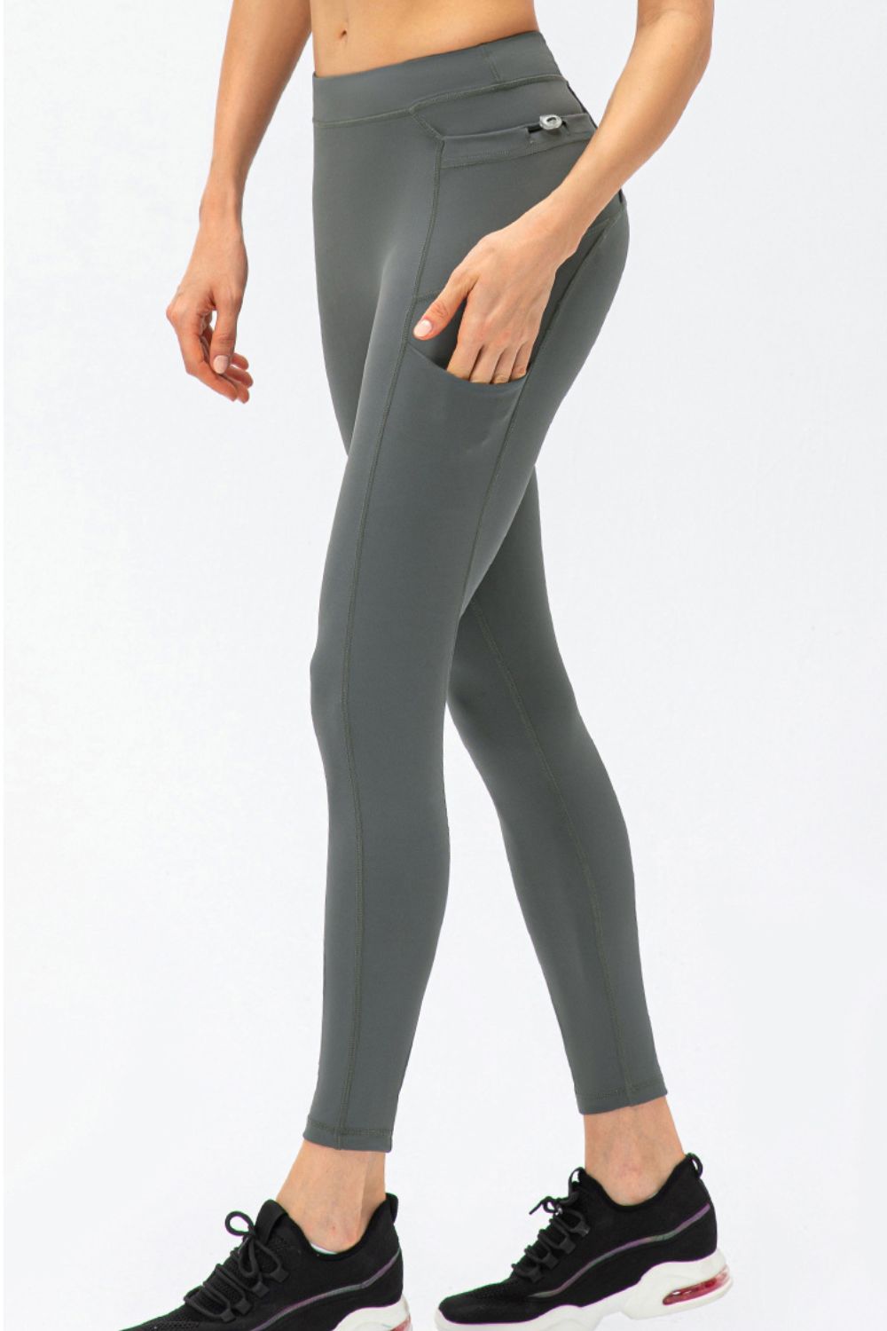 Black leggings styled with a phone in the side pocket and a towel at the hip
