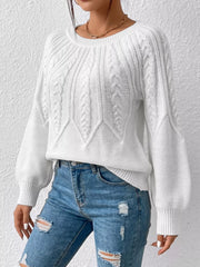 White cable-knit sweater shown from the front with sleeves relaxed