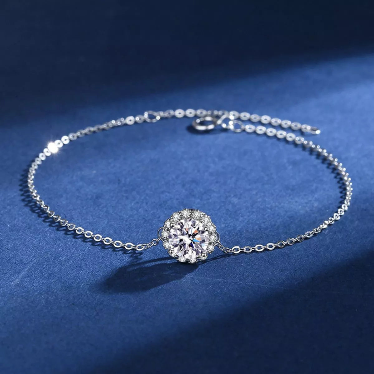Silver moissanite bracelet arranged on dark blue fabric