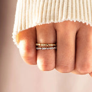 Gold-tone and silver-tone zircon bands worn stacked on a hand