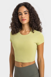Model wearing a pale yellow cropped sports T-shirt, front view