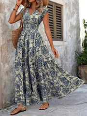Blue floral V-neck maxi dress on a model, with the tiered skirt sweeping to one side.