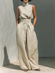 Front view of the cream sleeveless turtleneck top with wide-leg trousers and tied waist.